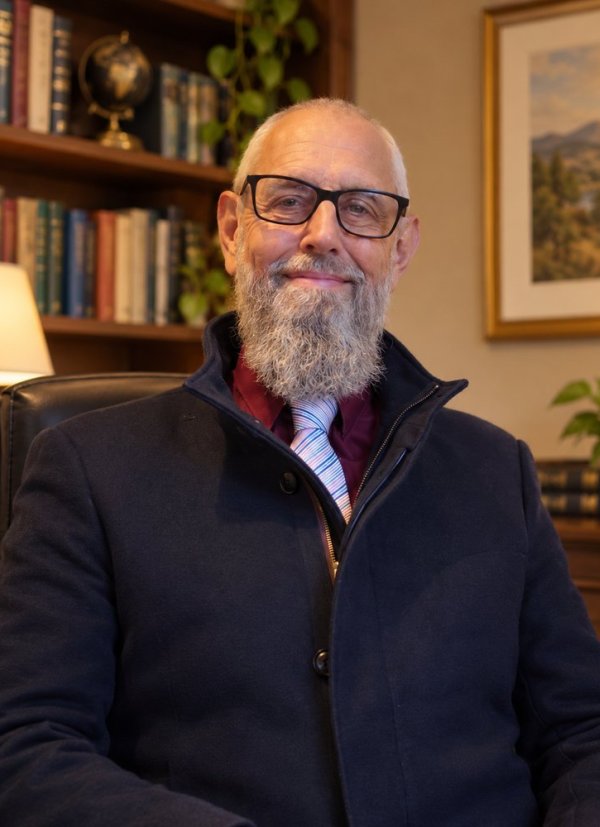 Shaun T. Richards, linguist and AI evaluator, smiling in a warmly lit study.